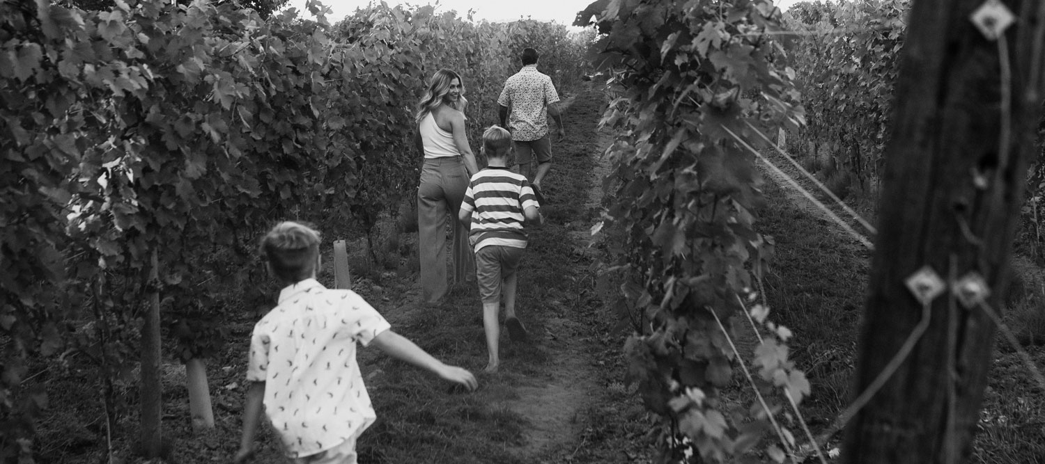 The family that owns Cannon Estate Winery with their two boys playing in the vineyard